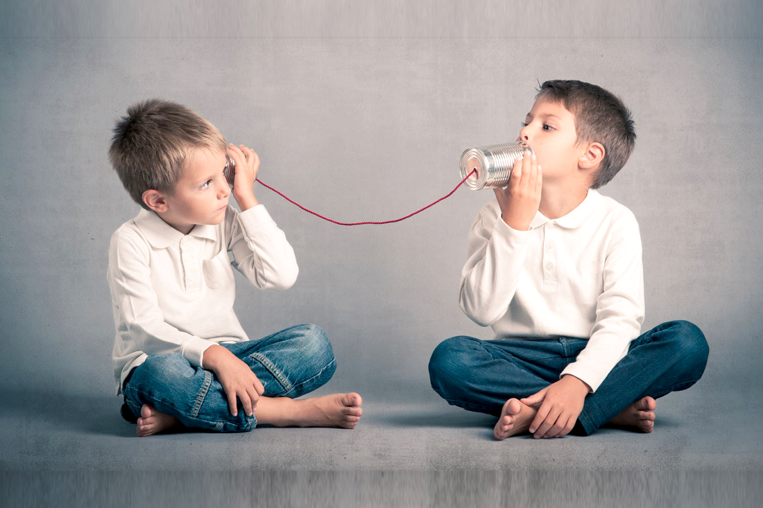 Due bambini comunicano con barattoli di latta – ritrovare il dialogo è possibile